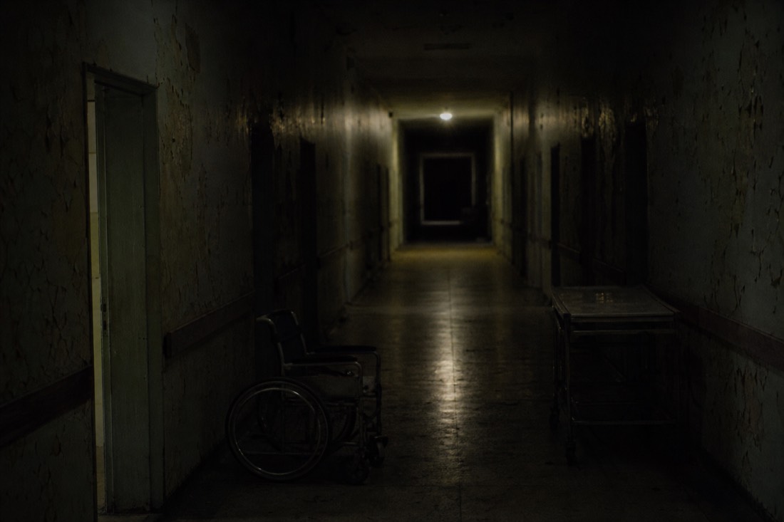 Long derelict hospital corridor stretching into darkness, like Fuji-Q's 900-meter horror maze