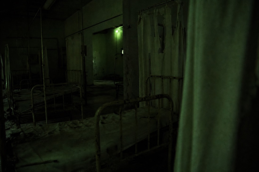 Abandoned hospital ward in near-darkness inside a walk-through horror attraction