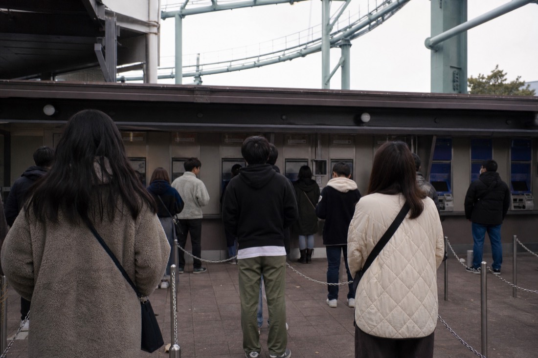 Ticket machines and queues at a Japanese amusement park entrance