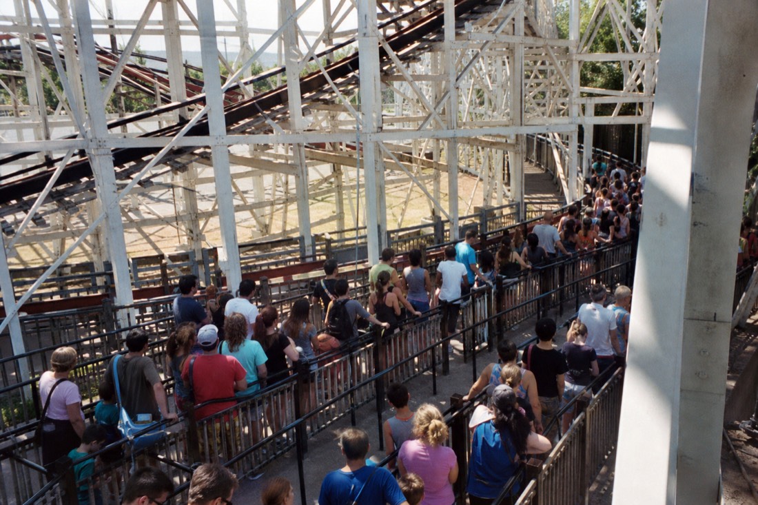 A long mid-afternoon ride queue snaking under a towering steel coaster at Fuji-Q Highland, the biggest time-sink of the day
