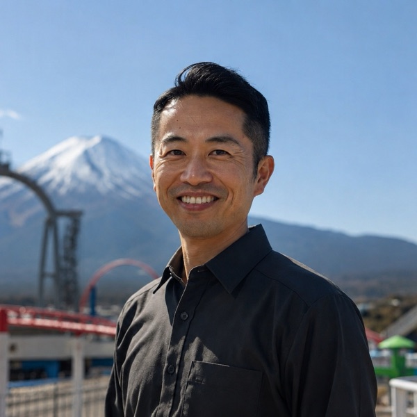 Portrait of Kenji Yamamoto at Fuji-Q Highland with Mount Fuji and the coasters behind him